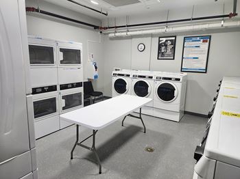 216 East state laundry room with a folding table and washing and dryer machines